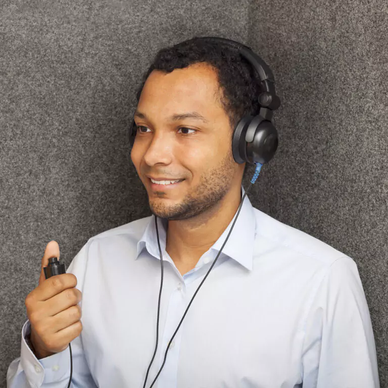 Patient responding to tones in a quiet hearing test booth